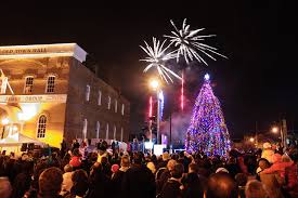 Christmas tree full of lights in night sky with crowd watching